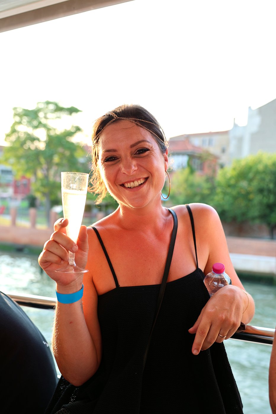Ospite che brinda con un calice di prosecco al tramonto