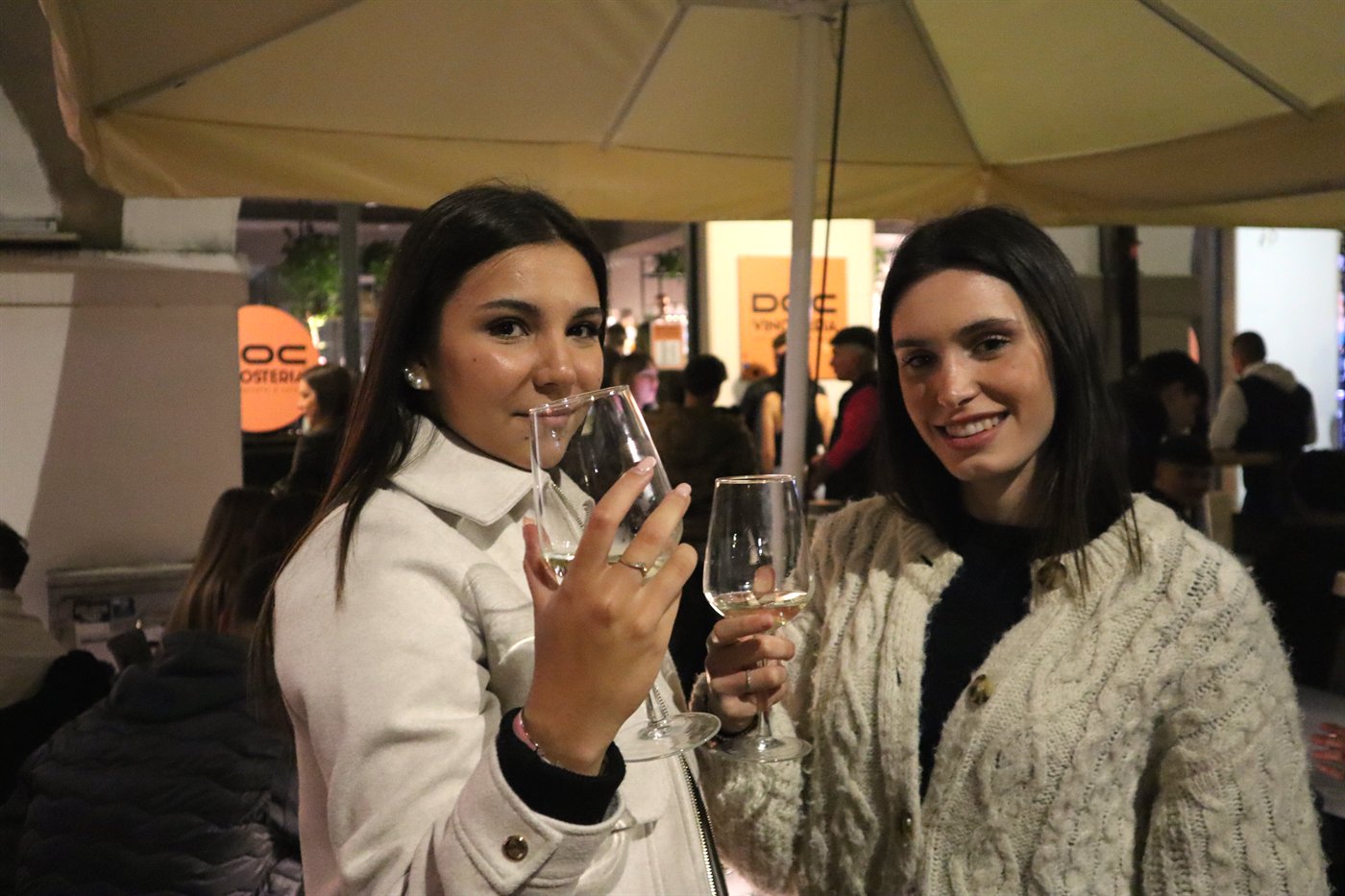 Due ospiti con calici di vino in un dehors