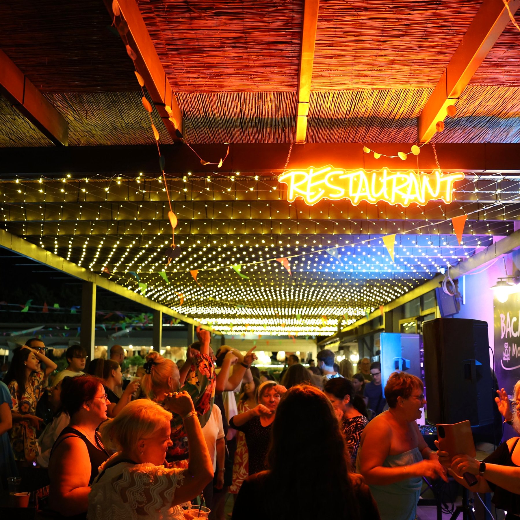 Serata con DJ sotto il pergolato illuminato di un ristorante